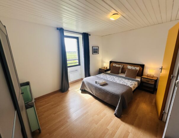 Chambre à l'étage du gîte droite avec un lit 160 cm, un lit 90 cm et un lit bébé