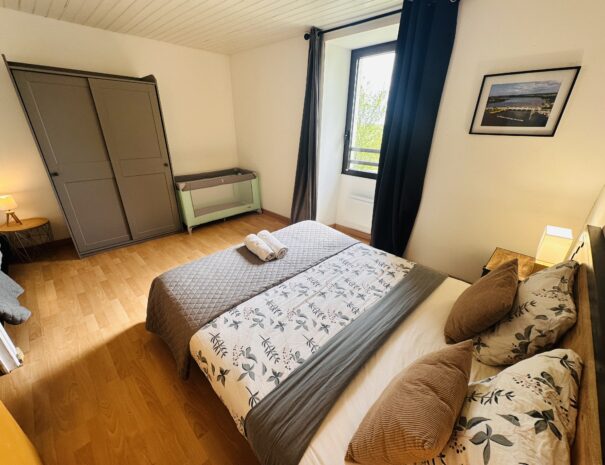 Chambre à l'étage du gîte droite avec un lit 160 cm, un lit 90 cm et un lit bébé