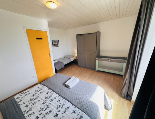 Chambre à l'étage du gîte droite avec un lit 160 cm, un lit 90 cm et un lit bébé