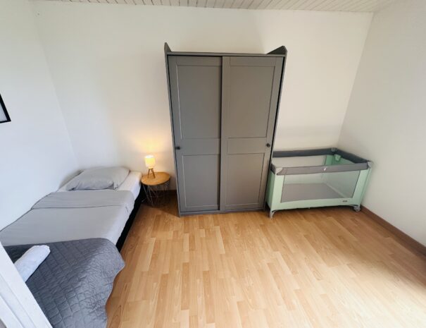 Chambre à l'étage du gîte droite avec un lit 160 cm, un lit 90 cm et un lit bébé