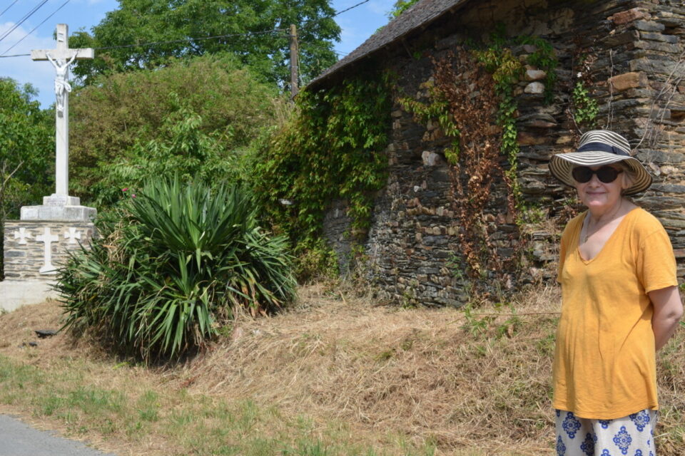 Karine Dutemple devant les mur, dernier vestige de l'ancienne chapelle du village de Gannedel, dont la destruction a conduit à l'édification de l'église Saint-Melaine puis au développement de son bourg.